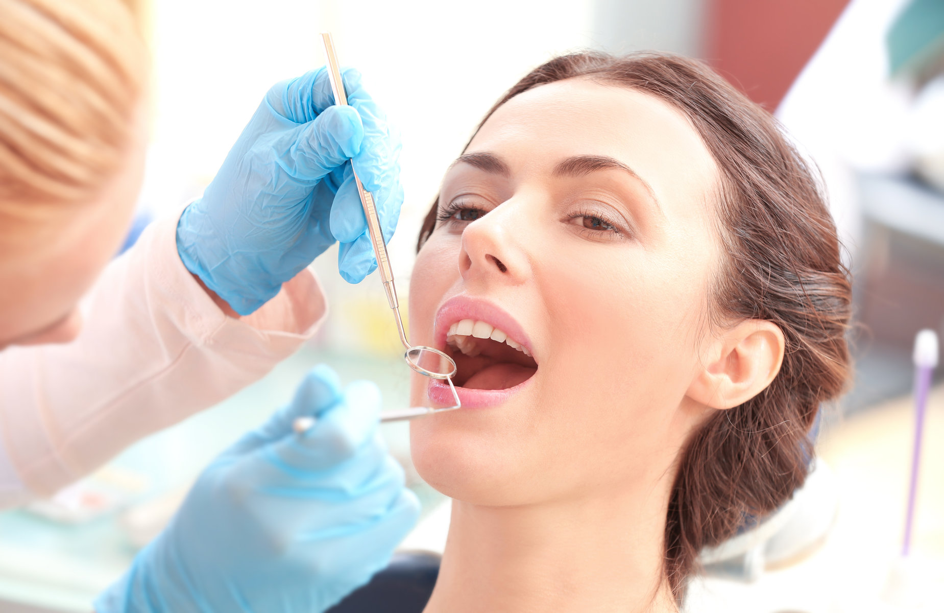 Dentist examining patient's teeth in clinic