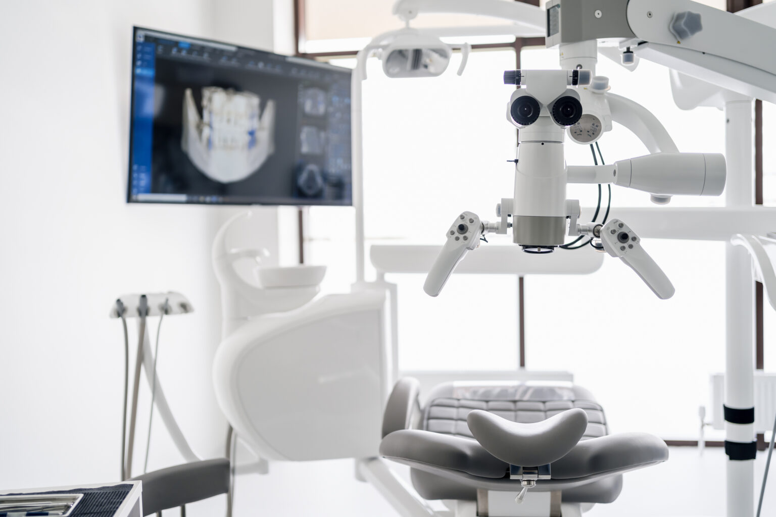 Interior of dental practice room with close up on microscope and dental scan on the display. Stomatology modern equipment